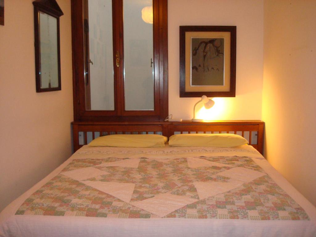 sypialnia z łóżkiem z kołdrą w obiekcie Cristina House w mieście Bassano del Grappa