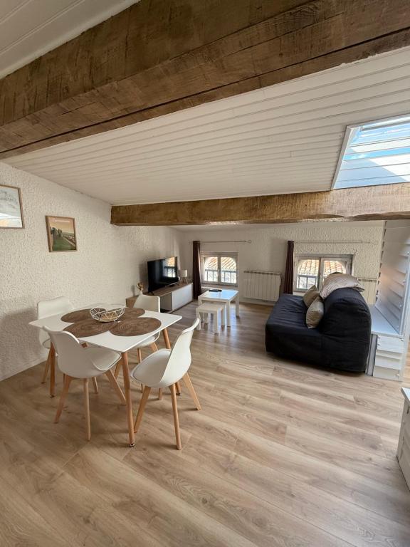 un salon avec un canapé, une table et des chaises dans l'établissement Le nid des remparts, à Carcassonne