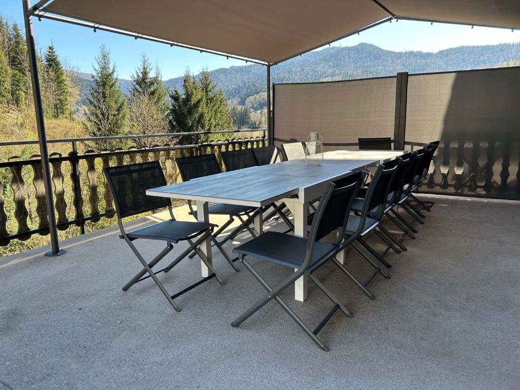 une table et des chaises sur une terrasse avec vue dans l'établissement Gîte 3 étoiles jusqu'à 12 pers, à Fresse-sur-Moselle