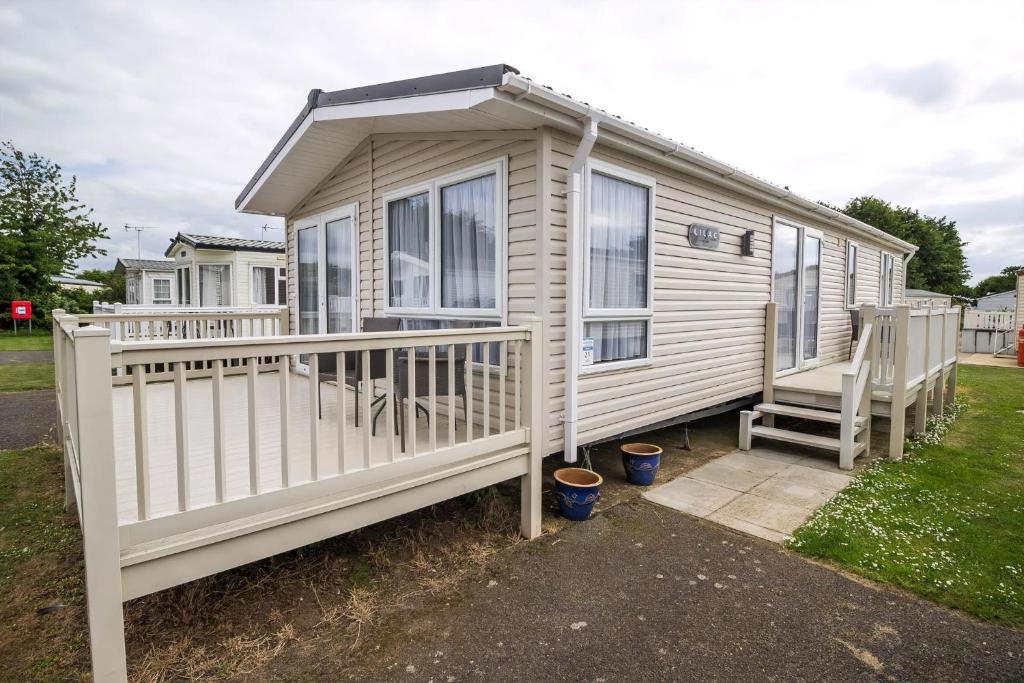 a mobile home with a porch and a deck at Beautiful Lodge At Manor Park Nearby Hunstanton Beach Ref 23021C in Hunstanton