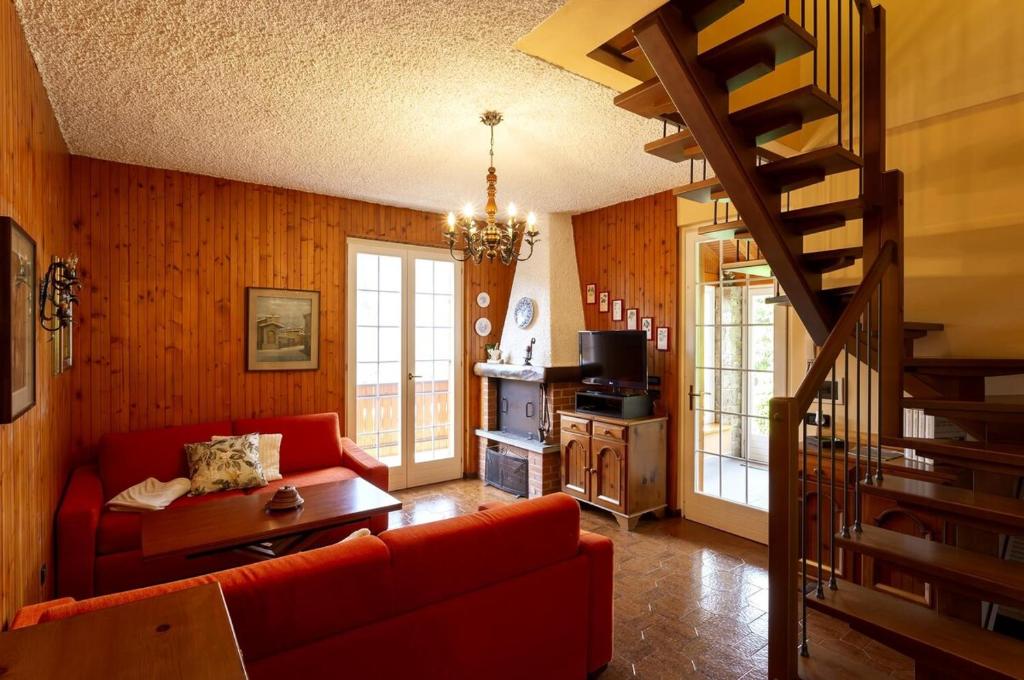 a living room with a red couch and a staircase at Villa Armonia Acero in Cerete