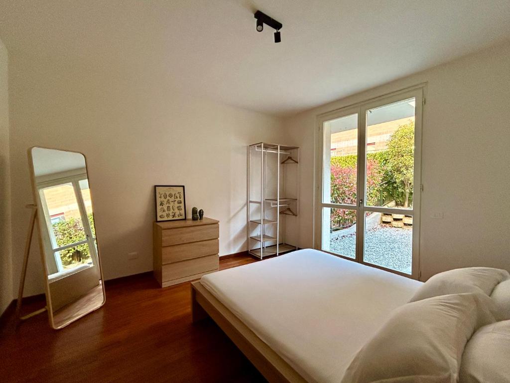 een slaapkamer met een bed, een spiegel en een raam bij Bellagio Wave Apartment in Bellagio