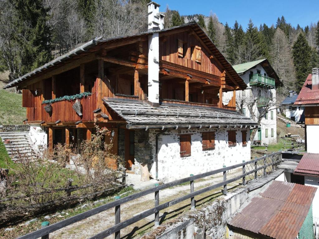 a large wooden building with a fence in front of it at Tabià Su'n Coi in Alleghe
