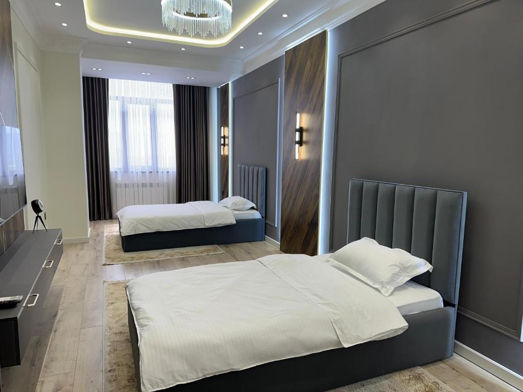 a bedroom with two beds and a desk at Dushanbe Place Apartments 2 in Dushanbe