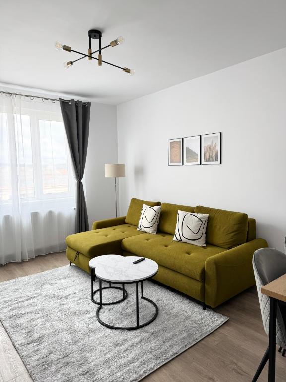 a living room with a green couch and a table at Central View Apartment in Târgu-Mureş