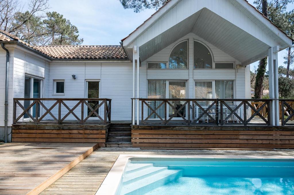 une maison avec une piscine devant dans l'établissement Villa Ocean, à Biscarrosse