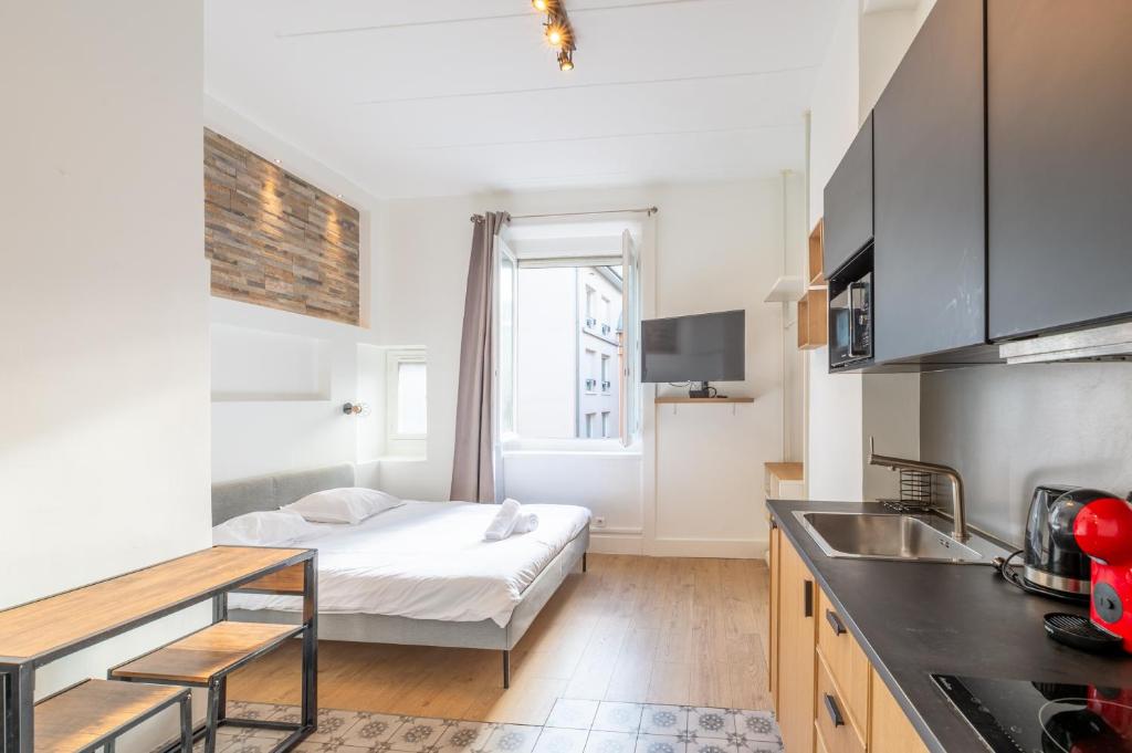 Ce petit appartement comprend un lit et une cuisine. dans l'établissement Escapade de Lyon, Relax & Balnéo Métro Charpennes, à Villeurbanne