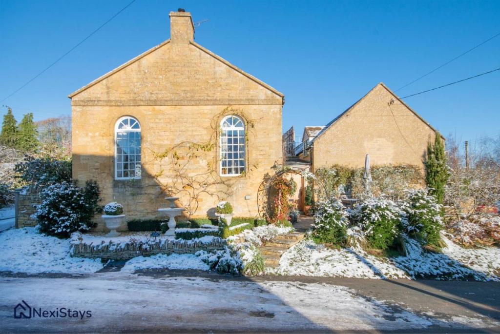 LongboroughにあるPrime Cotswold Location, The Old Chapel Longboroughの地面に雪が積もった大きなレンガ造りの教会