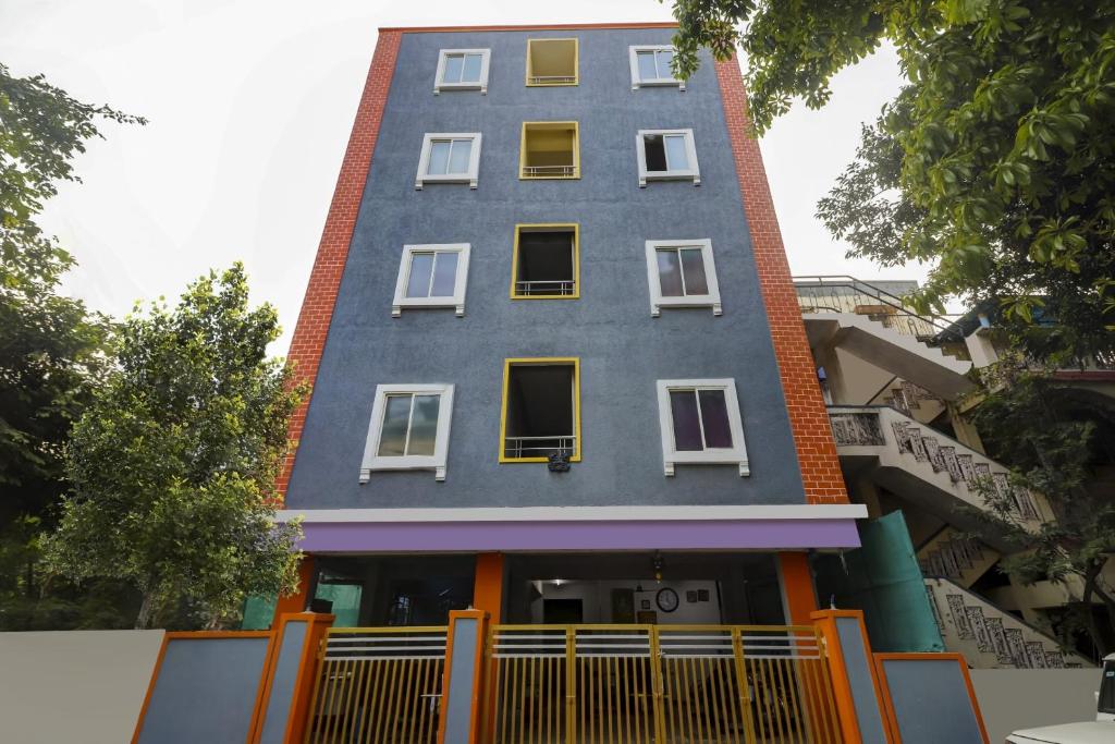 una casa azul con ventanas blancas en una calle en Hotel O Srinidhi Inn, en Ameerpet