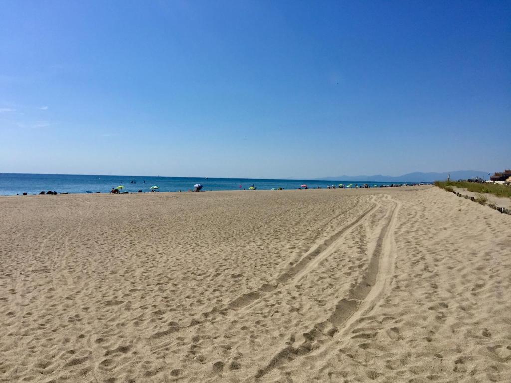 une plage avec des empreintes de pas dans le sable et l'océan dans l'établissement Maison à deux pas de la plage, au Barcarès