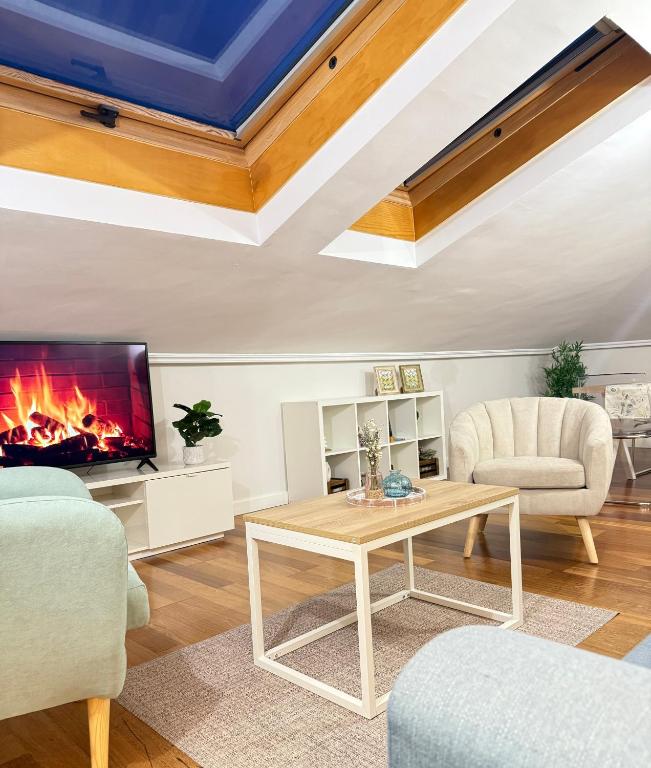a living room with a fireplace and a table at MIRADOR DEL CIELO "Parking incluido" in Ávila