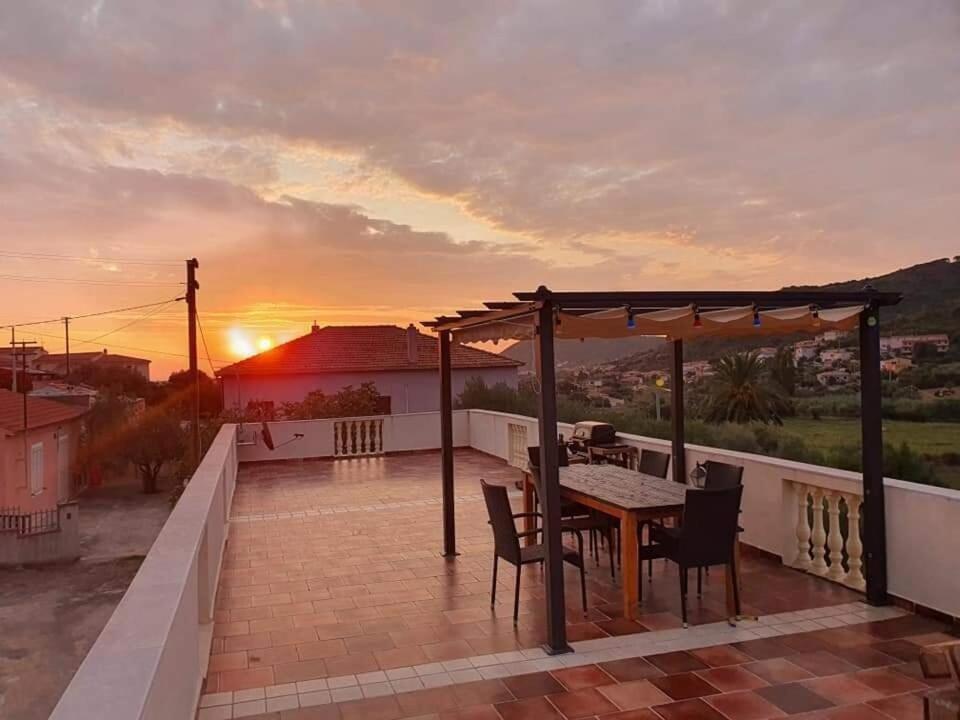 a table and chairs on a balcony with a sunset at Casa Pellegrino in Solità