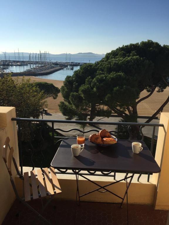 une table avec une assiette de nourriture sur un balcon dans l'établissement Vue Golfe St Tropez à Ste Maxime YourHostHelper, à Sainte-Maxime