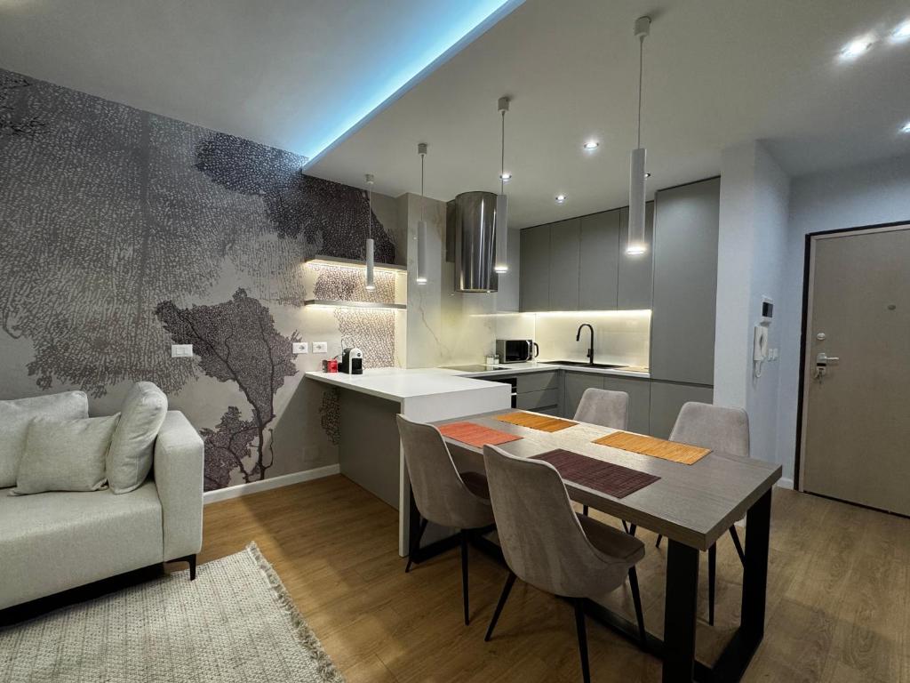 a kitchen and dining room with a table and a couch at Prive Luxury Apartments -City Center & Seaside in 1 in Vlorë