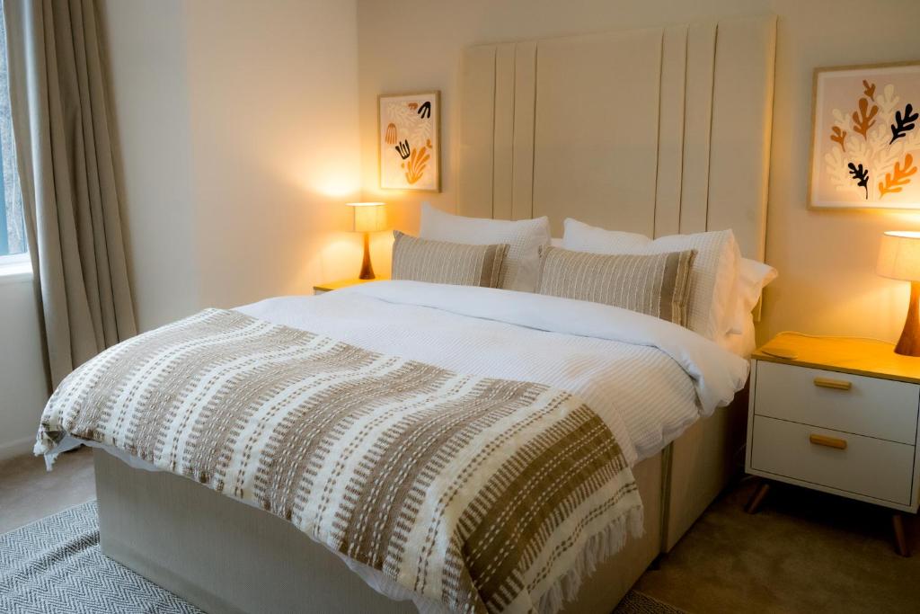 a bedroom with a large bed with two lamps at Luxury seaside getaway Whitley Bay in Whitley Bay