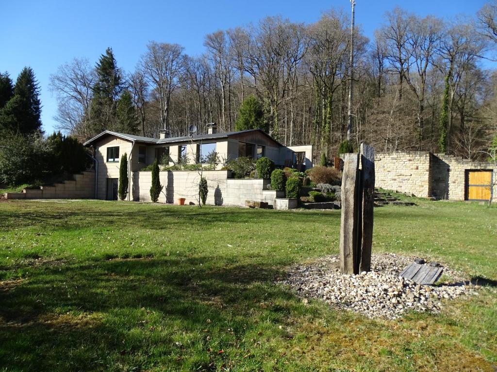a house in the middle of a field at Ferienhaus Eifelgruß, in schöner Waldrandlage und tollem Naturgarten in Oberbettingen