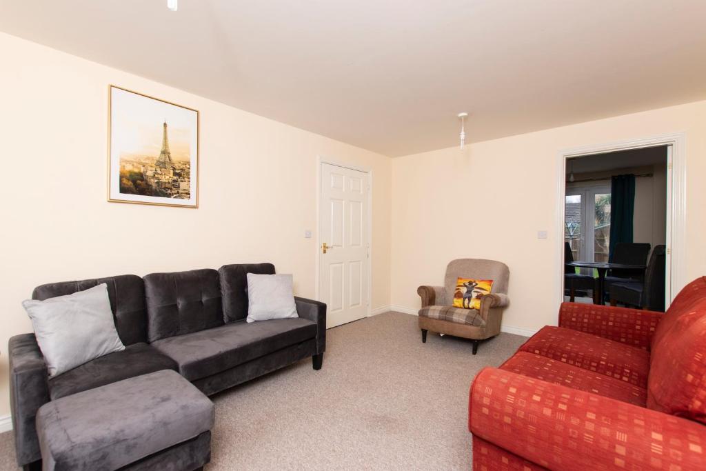 a living room with a couch and a chair at Magnolia Lodge in Norwich