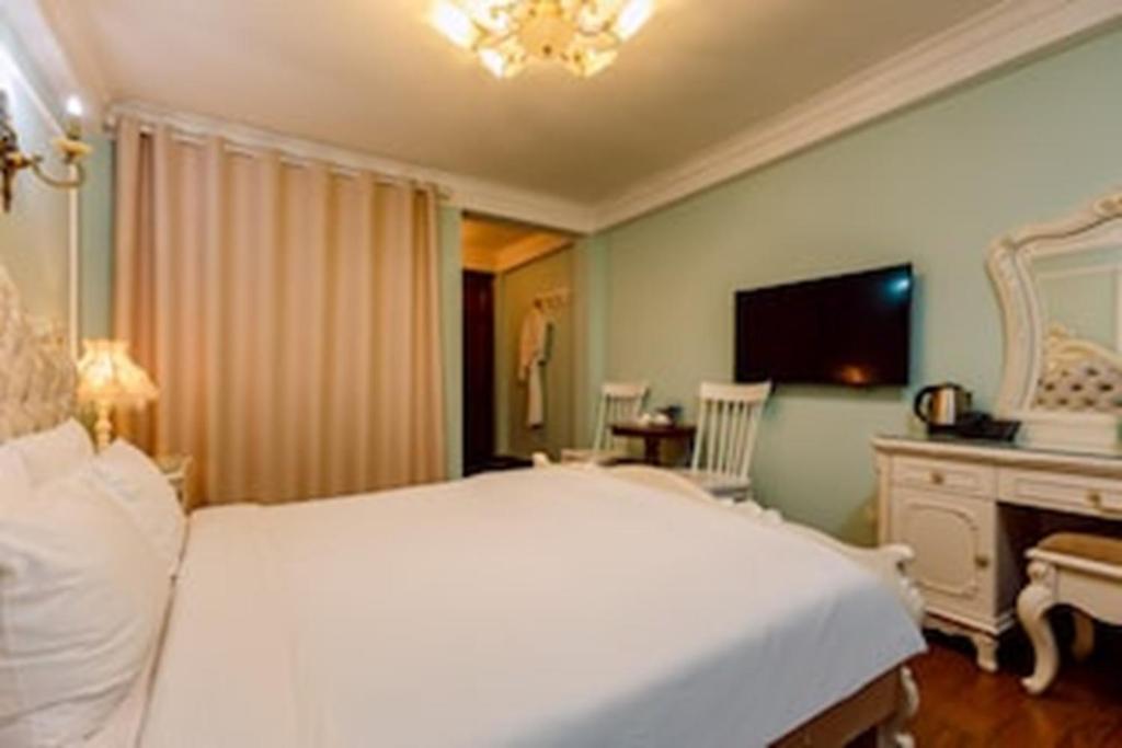 Postel nebo postele na pokoji v ubytování Super OYO Capital O 1173 Le Grand Hanoi Hotel - The Ruby