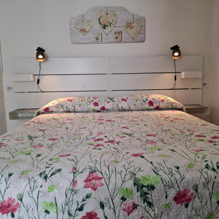 a bedroom with a bed with a floral bedspread at Phiniscollis B&B in La Caletta
