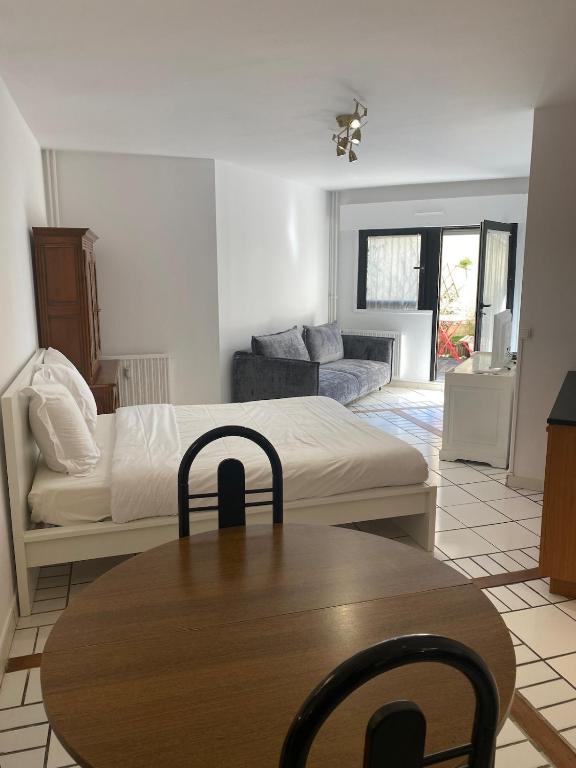 Cette chambre comprend un lit, une table et un canapé. dans l'établissement Ben's Studio Lac de Créteil, à Créteil