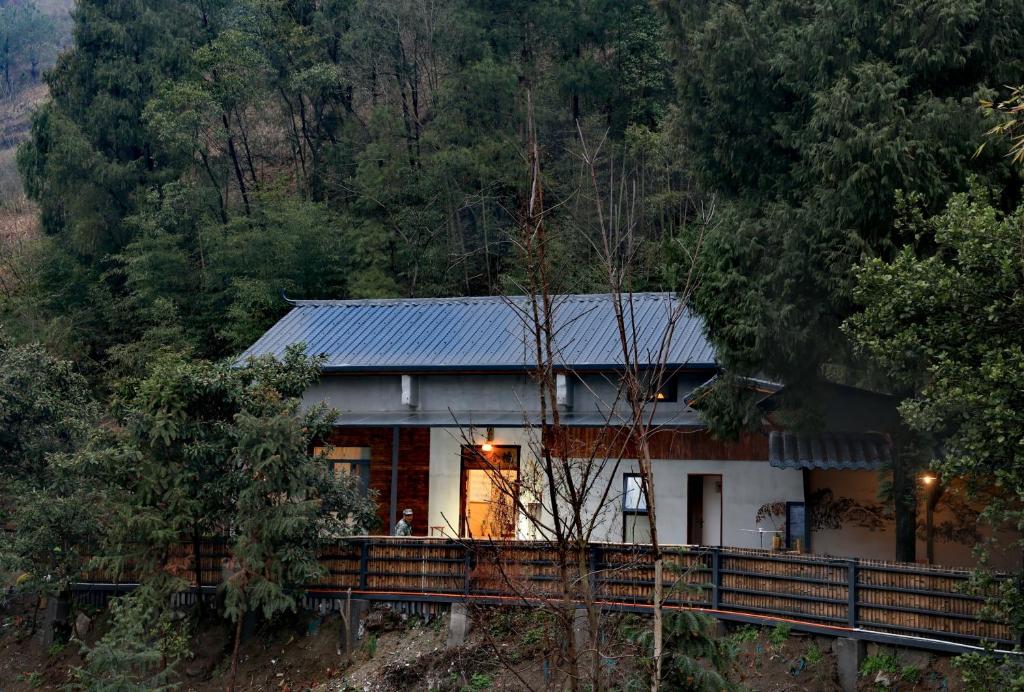 a house in the middle of a forest at Nanshe MuXi Heritage Inn in Zhangjiajie