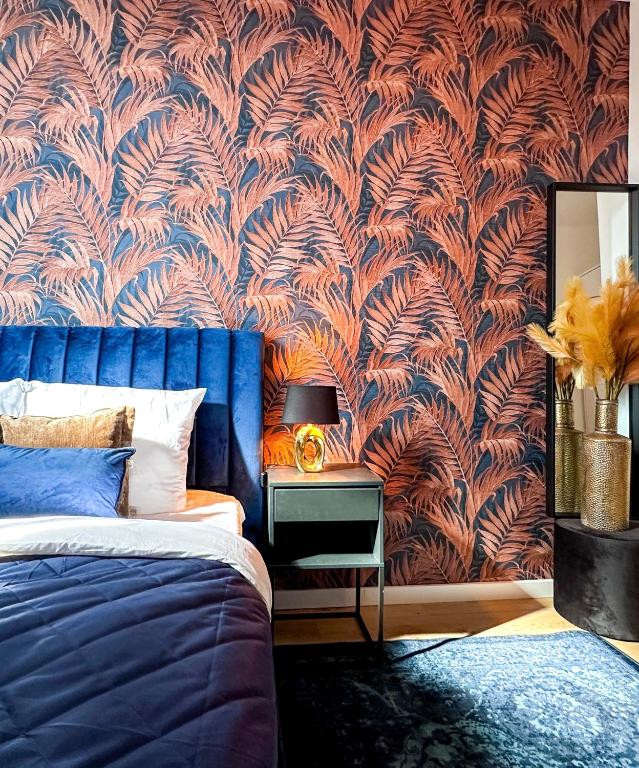 a bedroom with a blue bed and a wall mural at Cooth's Royale in Breda