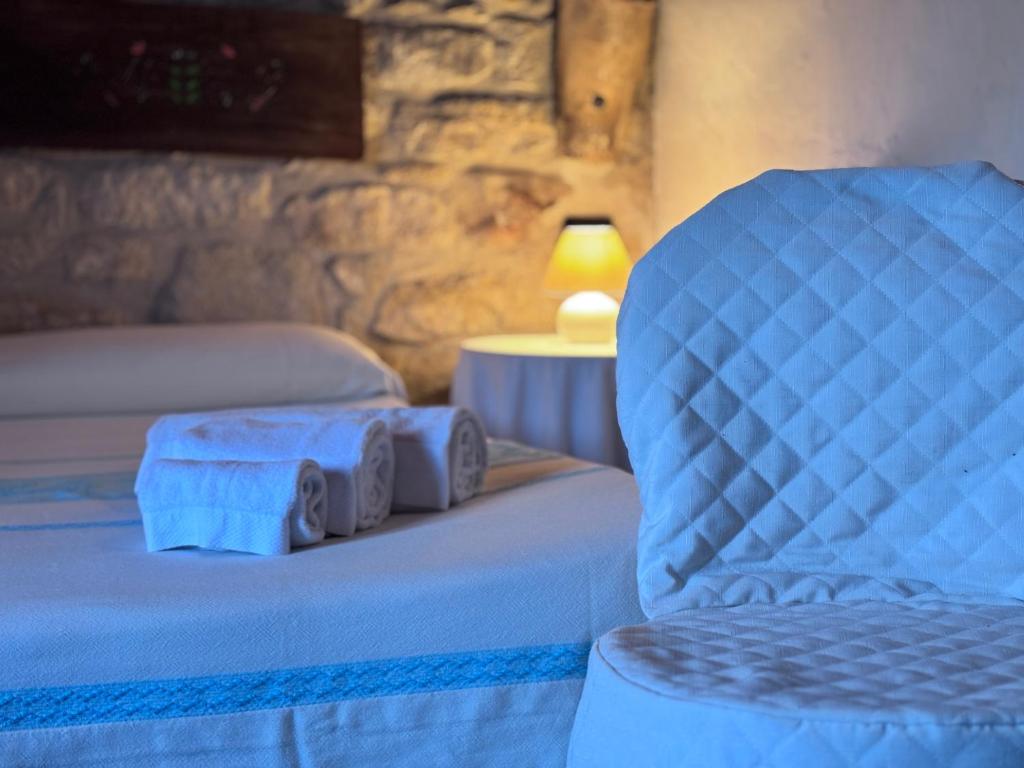 a bedroom with a chair and a bed with towels at Hammam Rooms, Senorbì, Sardegna in Senorbì