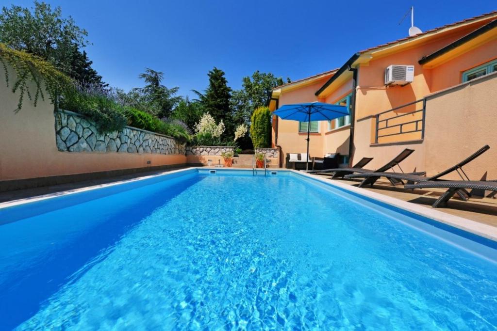 a swimming pool in a yard with a house at Villa Steffani in Labin