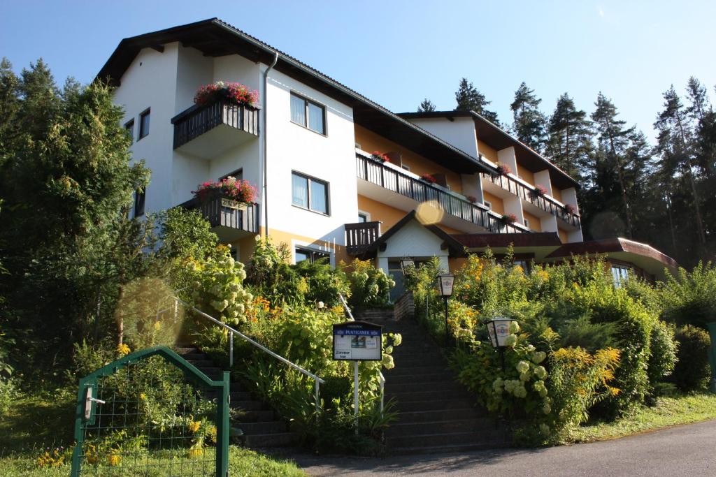 een gebouw met trappen en bloemen ervoor bij Ferienpension Garni Hubert Rigelnik in Sankt Kanzian