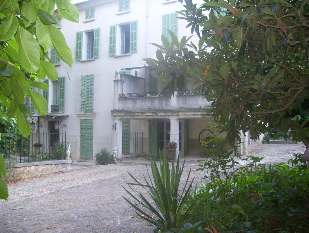 - un grand bâtiment blanc avec un balcon dans l'établissement Location maison domaine viticole avec piscine, à Flassans-sur-Issole