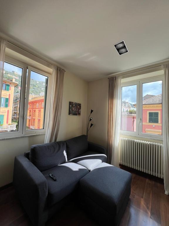 a living room with a couch and two windows at La casa di Eli in Genoa