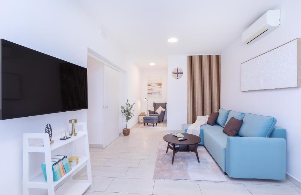 a living room with a blue couch and a tv at Apartment FraNiTo #3 - Charming Apartment close to Dubrovnik in Mlini
