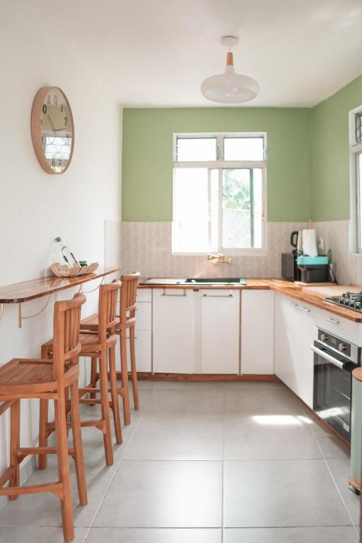 a kitchen with white cabinets and green walls at La Kaz and Ti Thano in Port-Louis