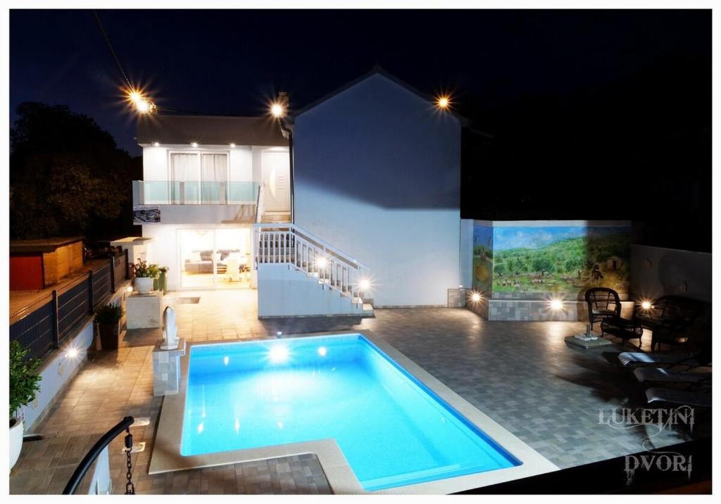 a swimming pool in front of a house at night at Villa Luketini Dvori, Primošten in Kruševo