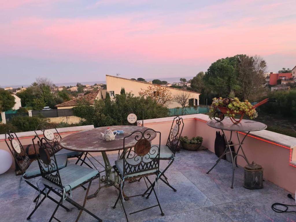 d'une terrasse avec 2 tables et des chaises sur un balcon. dans l'établissement Beautiful sea view, quiet in agricultural property, à Antibes