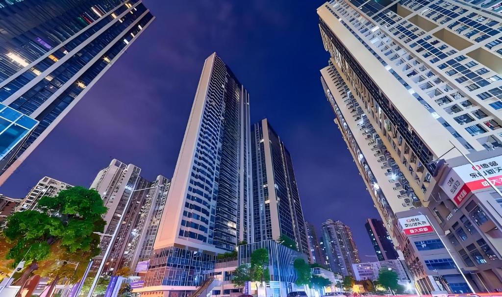 a group of tall buildings in a city at night at Heefun International Apartment - Zhujiang New Town FuLi Brand New World Plaza in Guangzhou