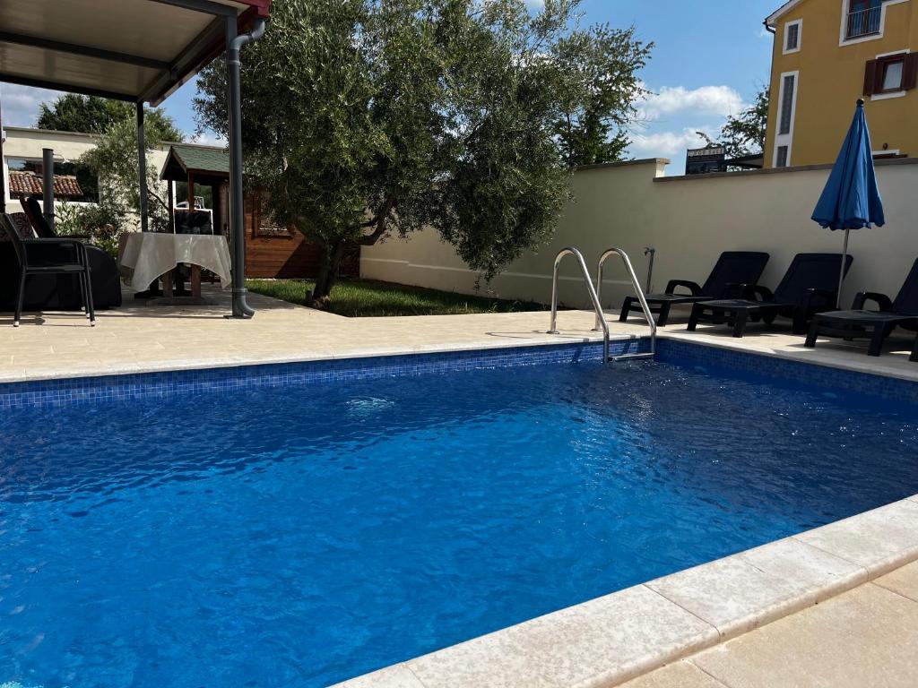 ein Swimmingpool mit blauem Wasser in einem Hof in der Unterkunft Dija Riva 1 in Vabriga