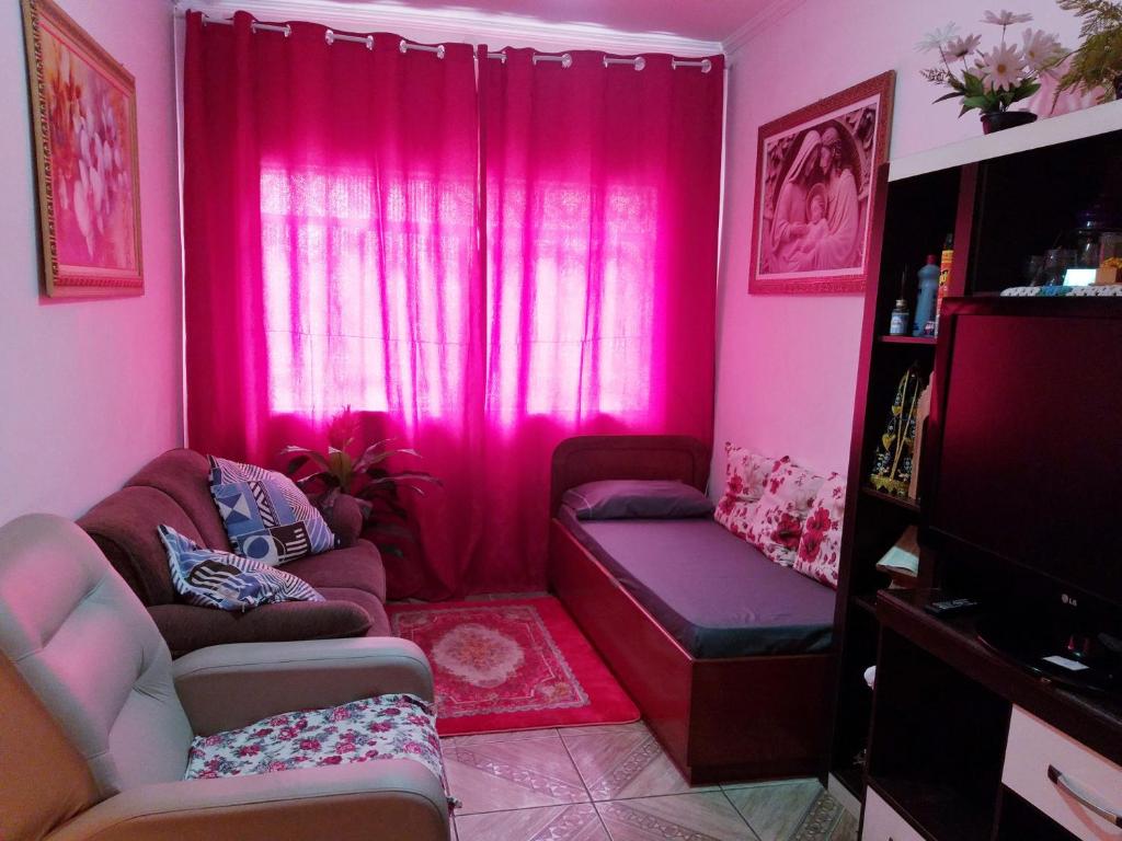 a living room with pink curtains and a couch at casa vó doca, preço único pela casa inteira,cabem até 10 pessoas ao lado da basilica aparecida in Aparecida