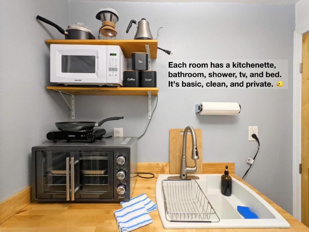 a kitchen with a microwave and a sink at Mangosteen in New Orleans