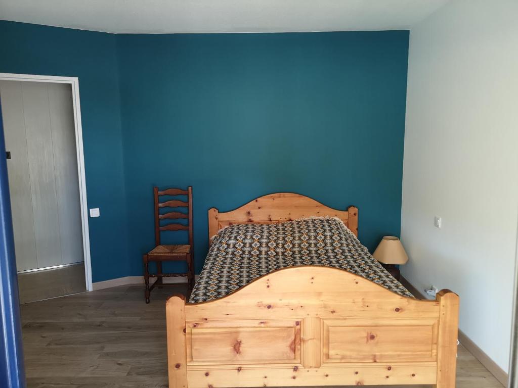 une chambre avec un lit en bois avec un mur bleu dans l'établissement Mandelieu Iselette du Riou, à Mandelieu-la-Napoule