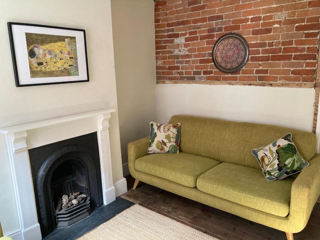 a living room with a couch and a fireplace at Painters Cottage, Grade II Listed, Salisbury in Salisbury
