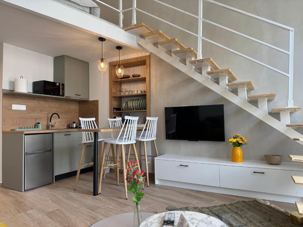 a living room with a kitchen and a living room with a staircase at Arches House Kavala private Parking in Kavala