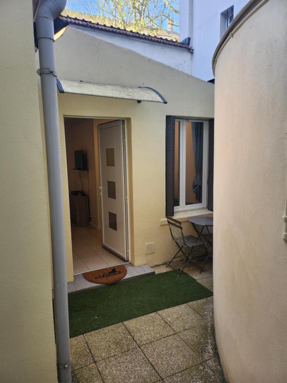 an open door of a house with a green floor at Maison studio in Paris