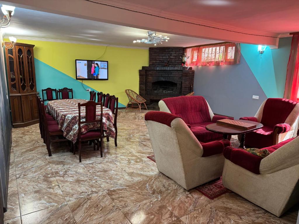 ein Esszimmer mit Tisch und Stühlen sowie einem Kamin in der Unterkunft DiliHome in Dilidschan