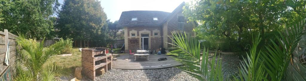 une grande maison avec une terrasse en bois devant elle dans l'établissement cétamé, à Étretat