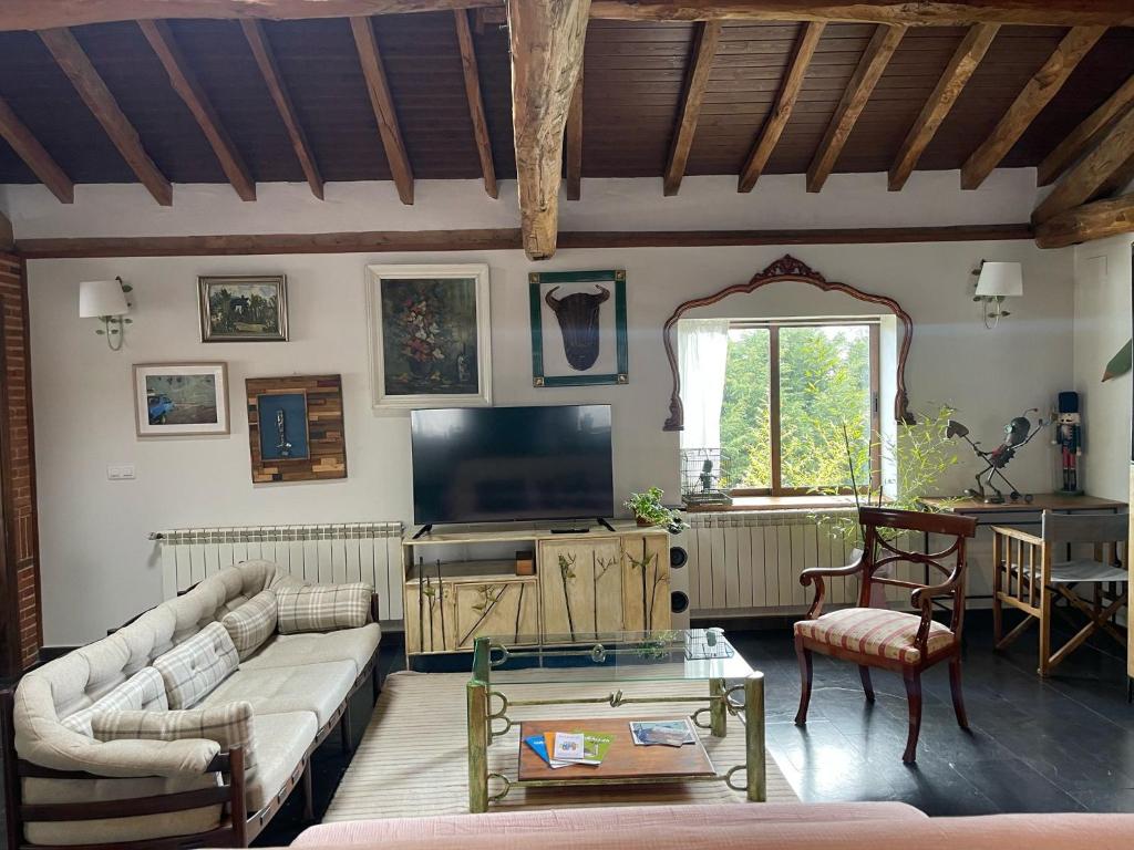 a living room with a couch and a tv at La Casa de Forja in Tarilonte