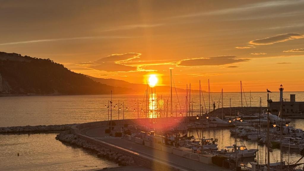 un groupe de bateaux amarrés dans une marina au coucher du soleil dans l'établissement Le LOFT MENTONNAIS, à Menton
