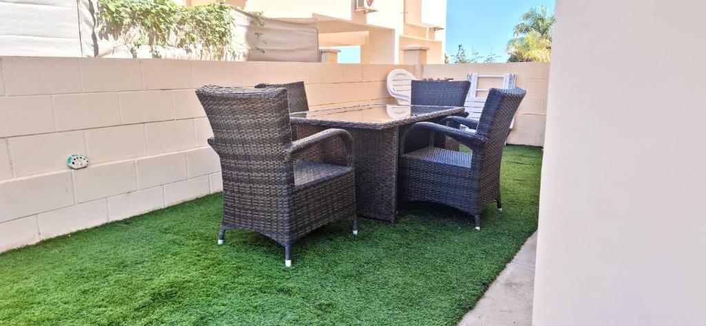 a patio with two chairs and a table on grass at AFRODITI APARTMENTs in Perivolia