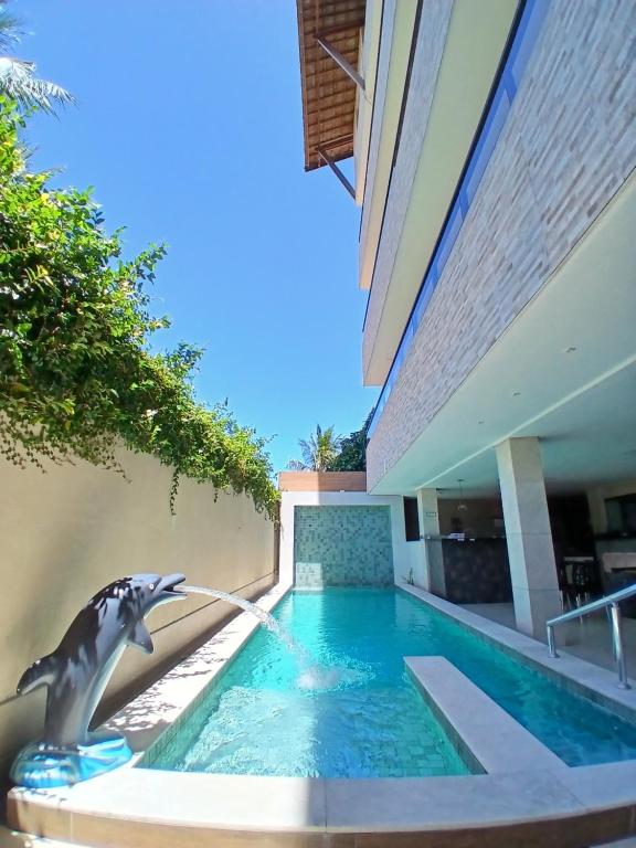 a swimming pool with a fountain in a house at Liszen flats in Porto De Galinhas