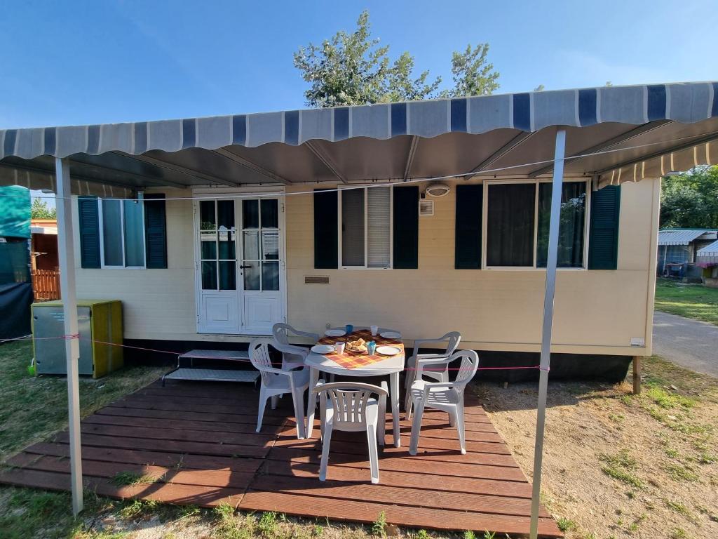 a house with a table and chairs on a deck at Mobile Home Emma in Lido di Dante